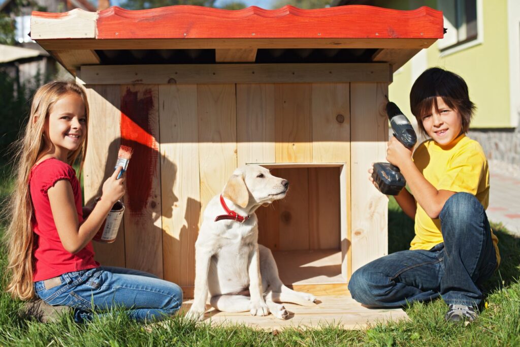 Children helping to build a dog kennel